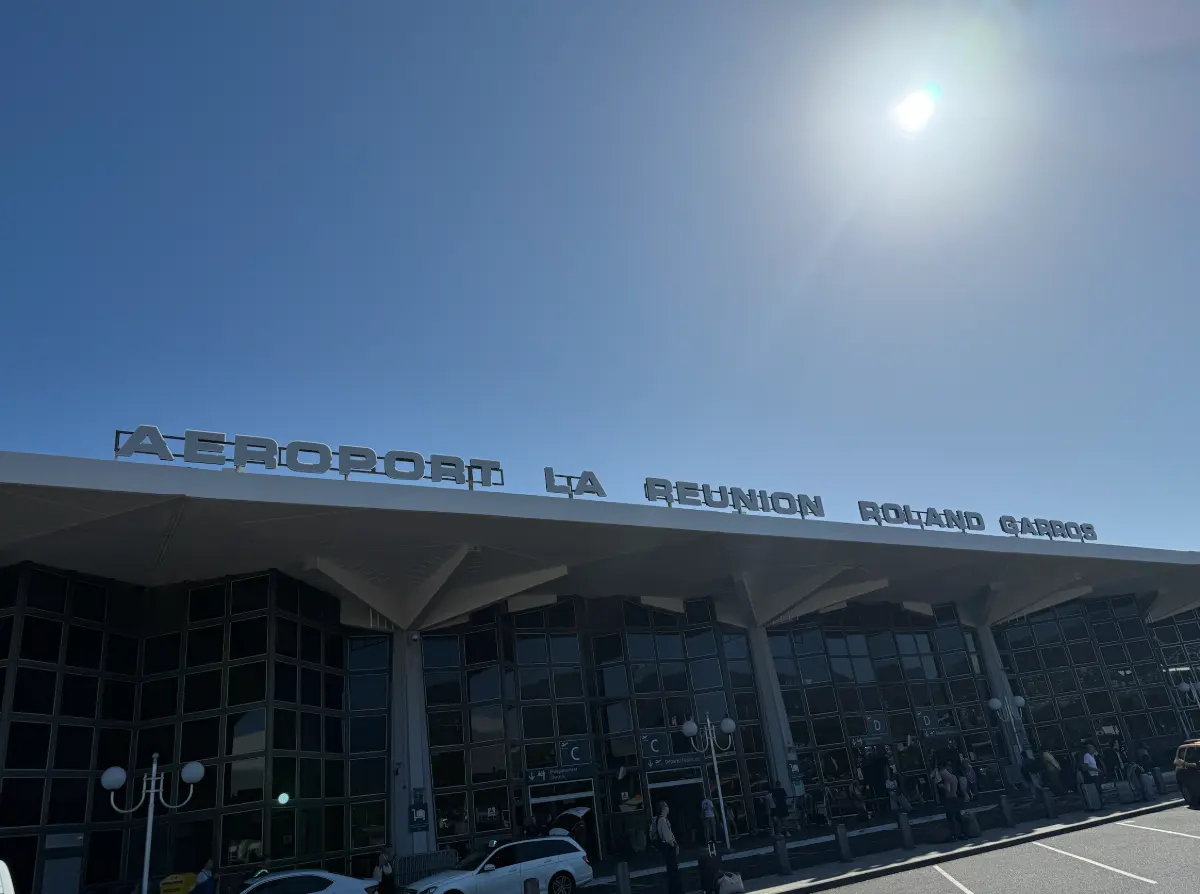 Façade de l'aérogare des départs de l'aéroport de La Réunion Roland Garros à Sainte-Marie, auvent en béton et enseigne en lettres métalliques