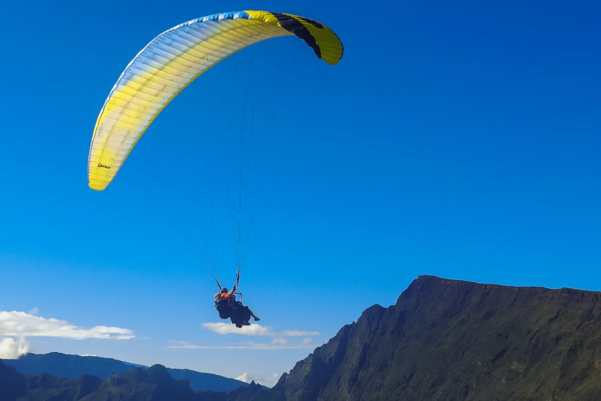 Parapente survolant les remparts du cirque de Mafate depuis le Maïdo, La Réunion