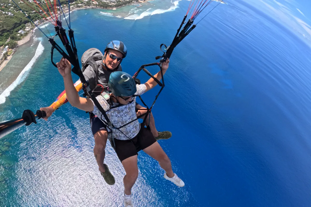 Passagers en parapente biplace survolant le lagon et la barrière de corail de Saint-Leu