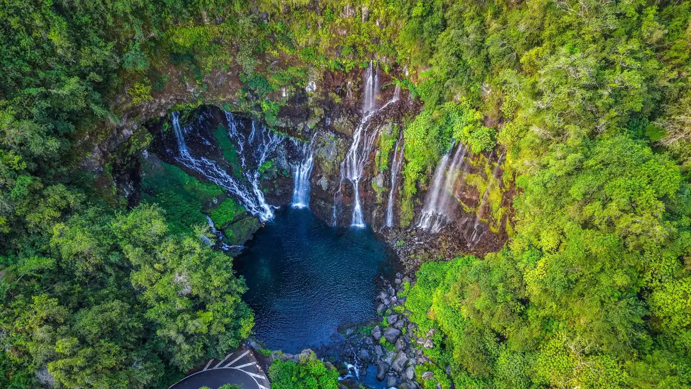 Vue aérienne de la cascade de Grand Galet sur la rivière Langevin : plusieurs chutes en éventail tombant dans un bassin sombre entouré de forêt