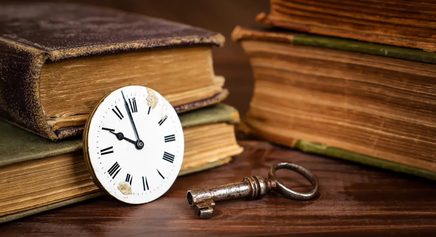 Clé ancienne, cadran d'horloge et livres anciens, ambiance d'escape game