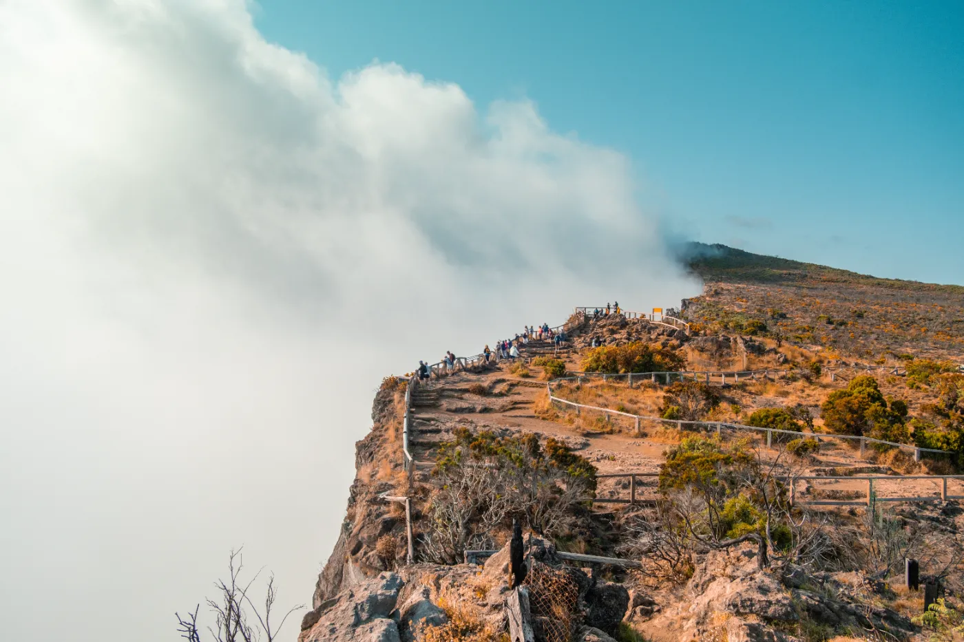 Randonneurs au belvédère du Pas de Bellecombe, au bord de l'enclos du Piton de la Fournaise, au-dessus des nuages